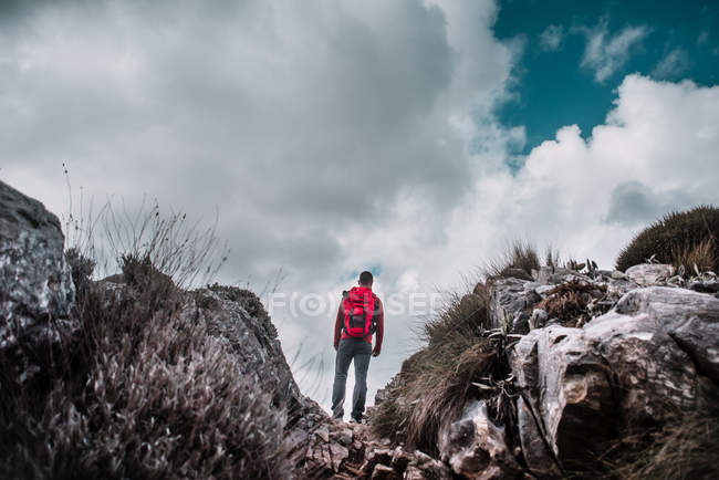 Backpacker standing in mountains — Stock Photo