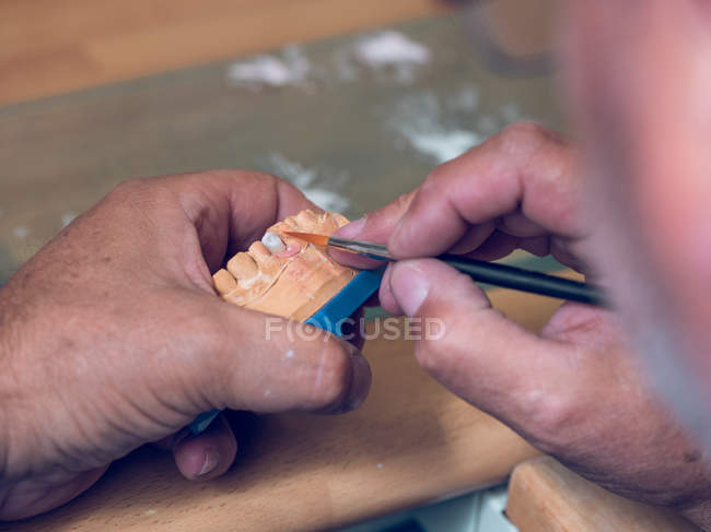 Руки нанесення речовини на зубний протез — стокове фото