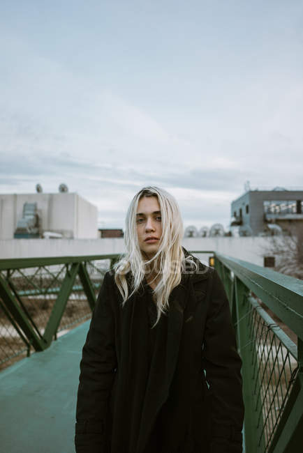 Женщина стоит на пешеходном мосту — стоковое фото