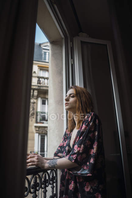 Femme debout à la fenêtre — Photo de stock
