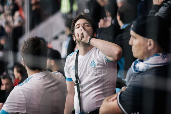 Futbolista mostrando señal de silencio en tribuna - foto de stock