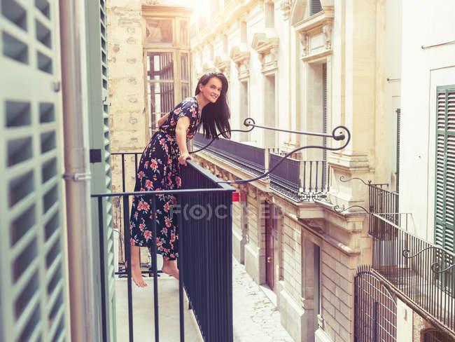 Femme debout sur le balcon en ville — Photo de stock