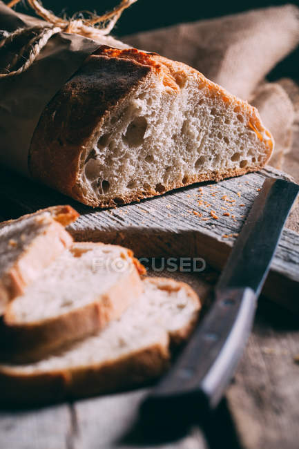Rustic bread loaf and slices — Stock Photo