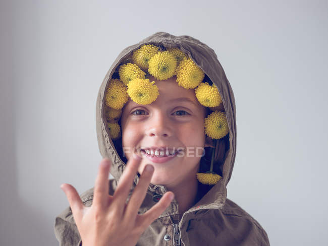 Niño con flores en la capucha - foto de stock
