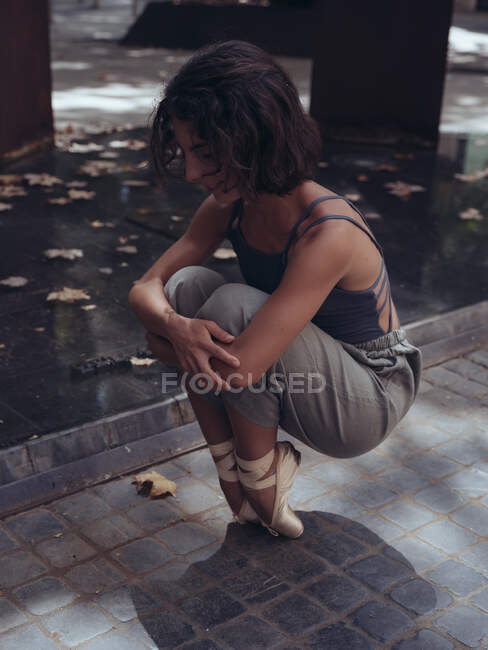 Jolie danseuse de ballet assise sur les orteils et s'entraînant dans la rue. — Photo de stock