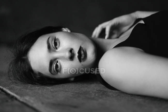 Frau liegt auf dem Boden und blickt in Kamera — Stockfoto