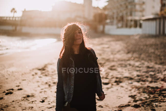 Женщина стоит на песчаном пляже — стоковое фото