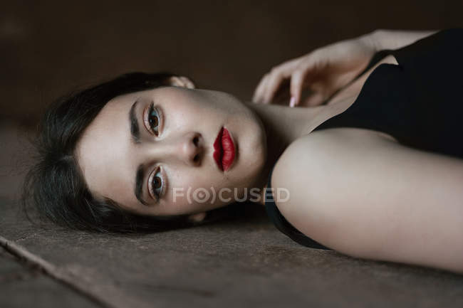 Frau mit dunklem Lippenstift auf dem Boden liegend — Stockfoto