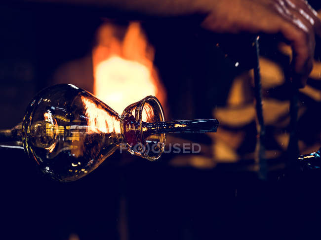 Vase made of glass on factory on background of burning furnace. — Stock Photo