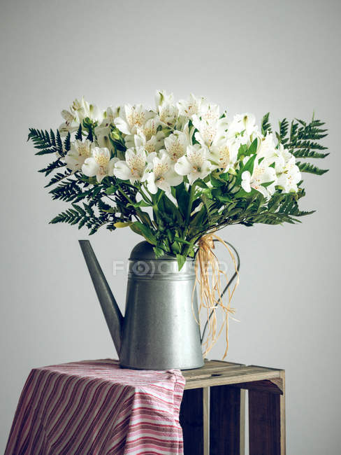 Bunch of flowers in watering can — Stock Photo