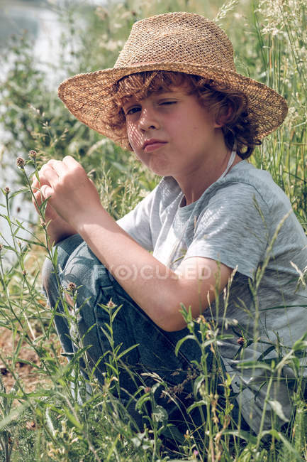 Niño sentado en el río - foto de stock