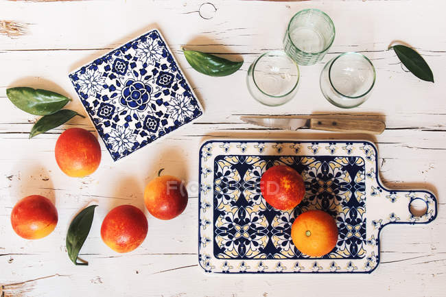 Fresh blood oranges and drinking glasses — Stock Photo