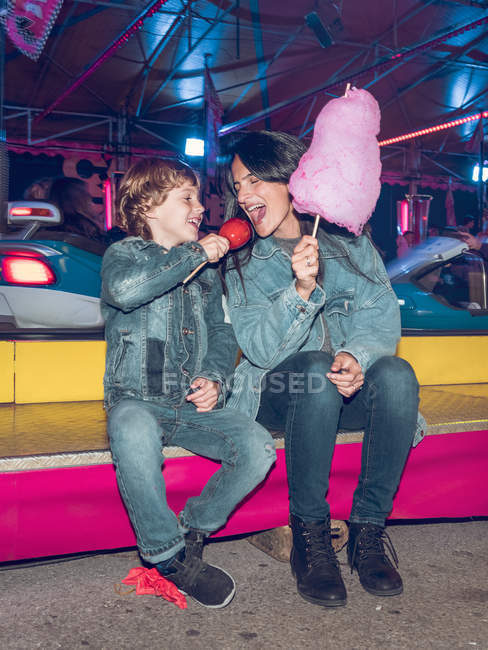 Madre e figlio con spuntini sul luna park — Foto stock