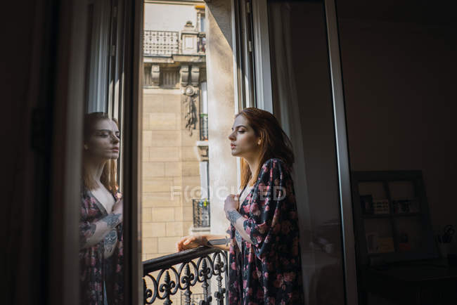 Жінка стоїть біля вікна — стокове фото