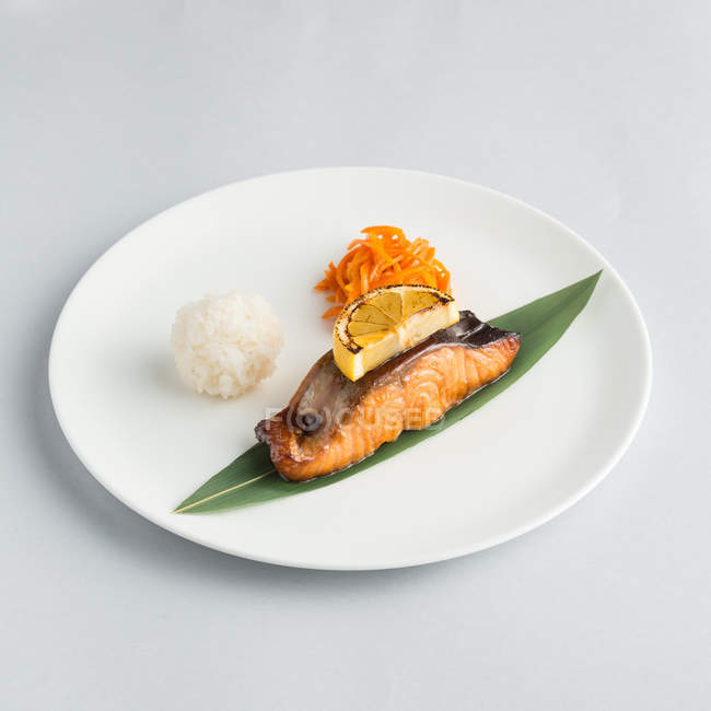 Композиция с жареным лососином и рисовым шариком — стоковое фото