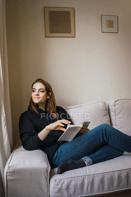 Femme de détente avec livre à la maison — Photo de stock