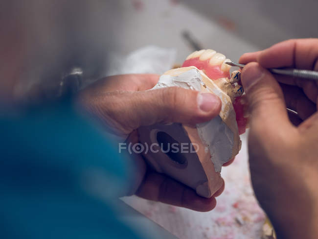 Dental technician carving tooth — Stock Photo