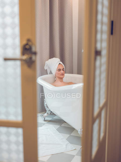 Jeune femme se détendre dans le bain — Photo de stock