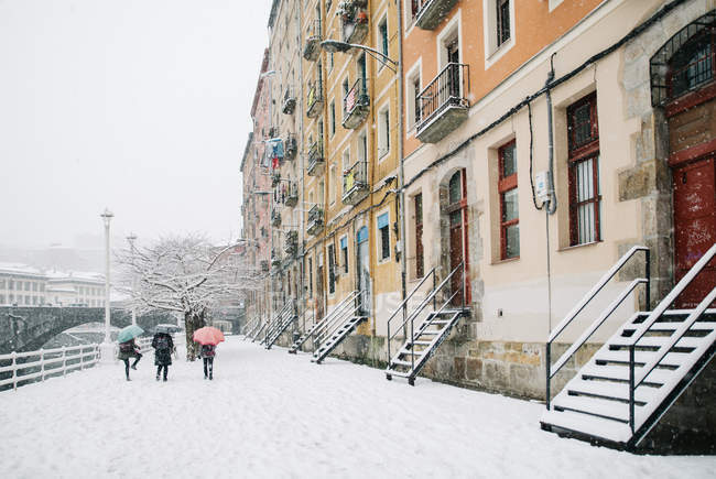 Unbekannte gehen auf verschneiter Straße in Bilbao, Spanien. — Stockfoto