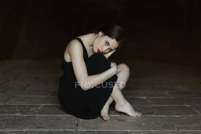 Jeune femme en robe noire — Photo de stock