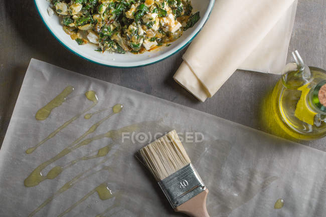 Füllung für traditionelle Spanakopita-Spinatkuchen mit Olivenöl und Pinsel — Stockfoto