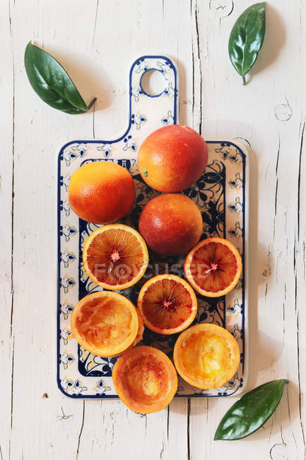Whole and squeezed blood oranges — Stock Photo