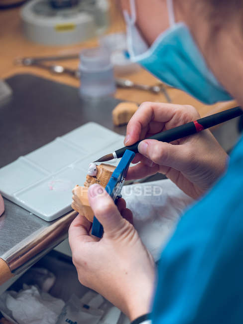 Стоматолог наносить речовину на зубний протез — стокове фото