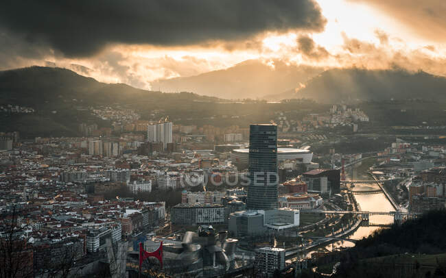 Modern skyscraper and old town under cloudy sky — Stock Photo