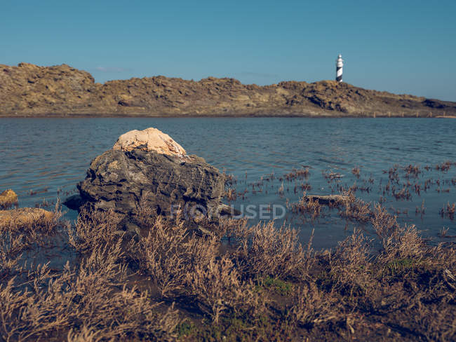 Leuchtturm auf Hügel und felsiger Küste — Stockfoto