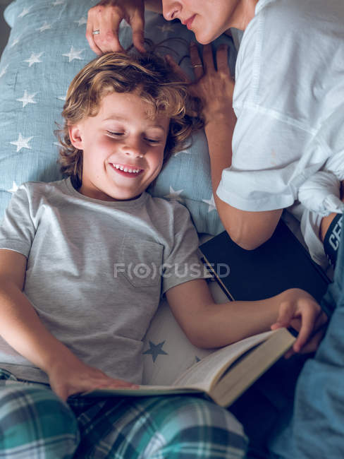 Figlio lettura libro con madre — Foto stock