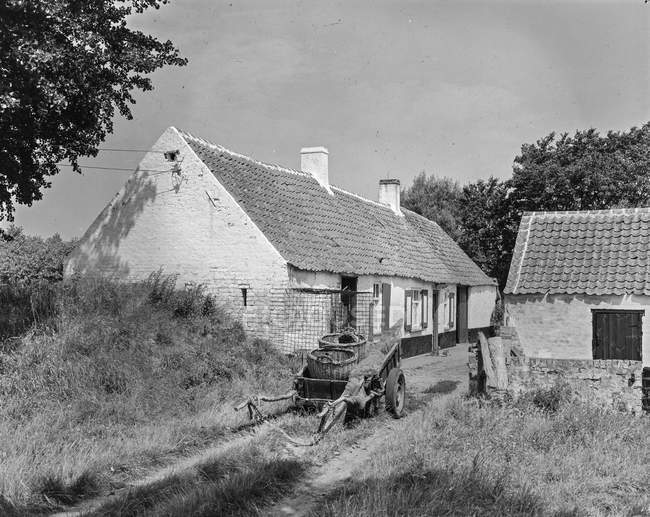 Schwarz-weiße Außenfassade eines Hauses mit Innenhof und Gartenbäumen im Dorf, Belgien. — Stockfoto
