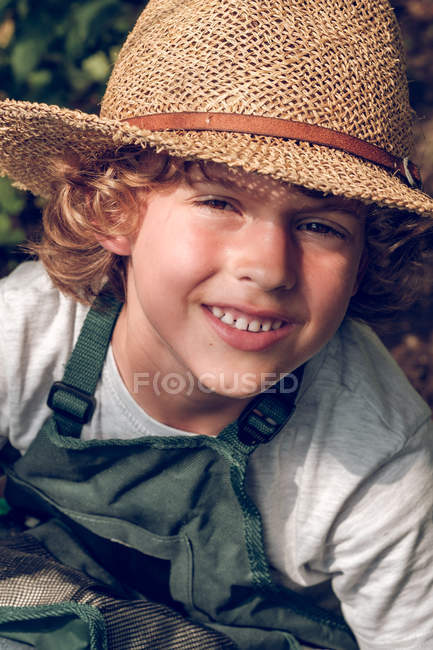 Ragazzo con riccioli in cappello di paglia — Foto stock