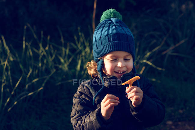 Улыбающийся мальчик держит гриб — стоковое фото