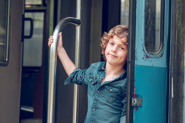 Niño de pie en vagón de tren - foto de stock