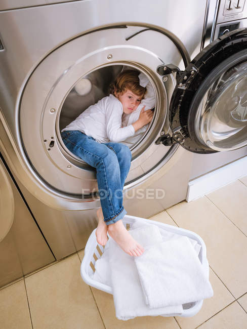Boy sleeping into laundry machine — Stock Photo