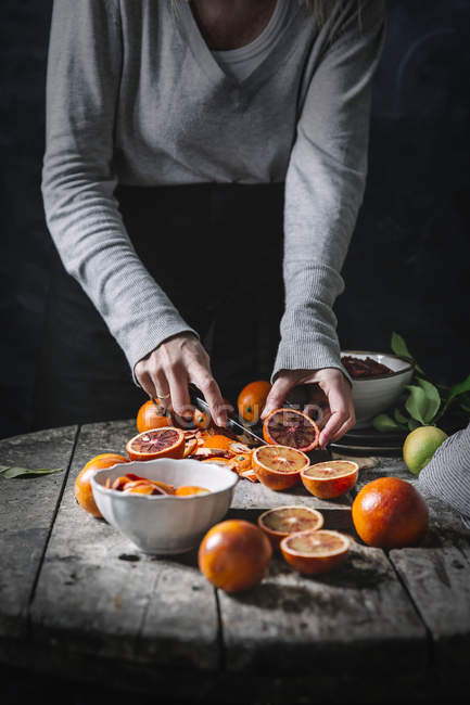 Hands peeling blood oranges — Stock Photo