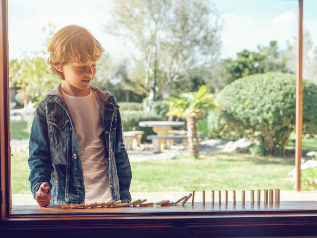 Мальчик играет с домино — стоковое фото