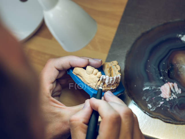 Dental technician applying enamel on mold — Stock Photo