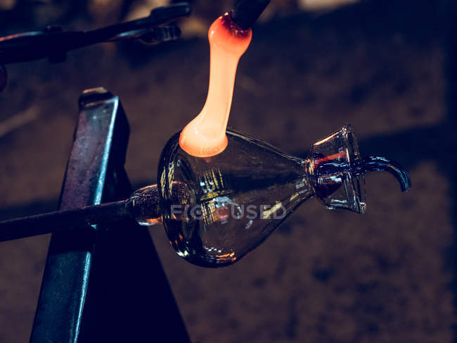 Close-up of glassblowing process of forming holder on glass jug at factory. — Stock Photo