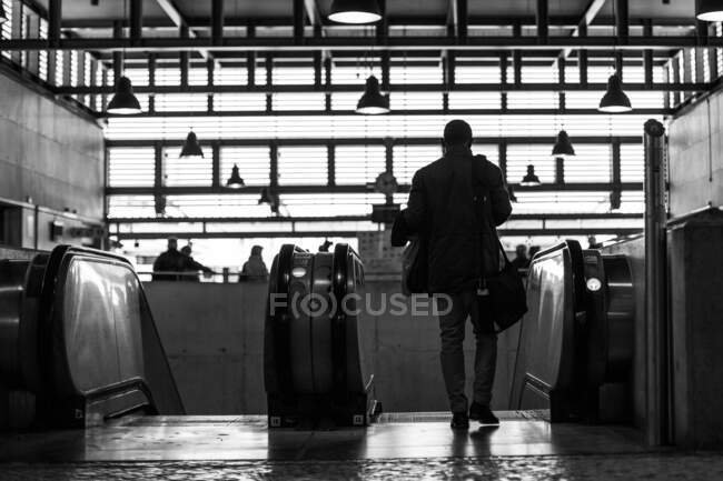 Человек на эскалаторе внутри вокзала РЕЛИЗ — стоковое фото