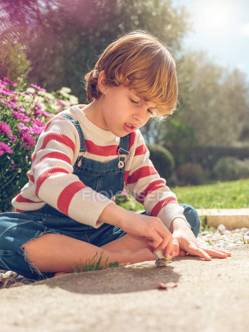 Junge spielt mit Kieselsteinen — Stockfoto