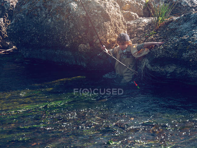 Маленький хлопчик стоїть у річці — стокове фото