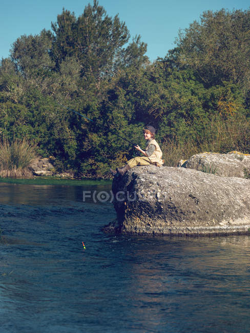 Ragazzo seduto e pesca — Foto stock
