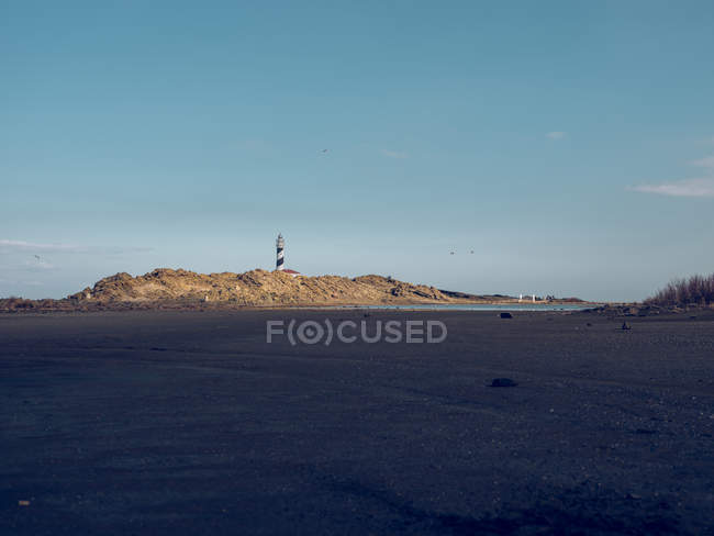Lighthouse tower on top of coastal hill — Stock Photo