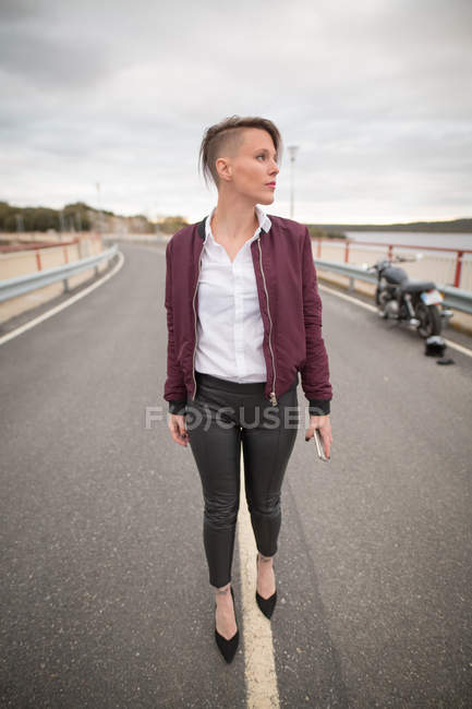 Mulher andando na estrada com smartphone — Fotografia de Stock