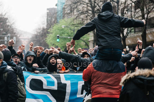 Crowd screaming with hands up on street — Stock Photo