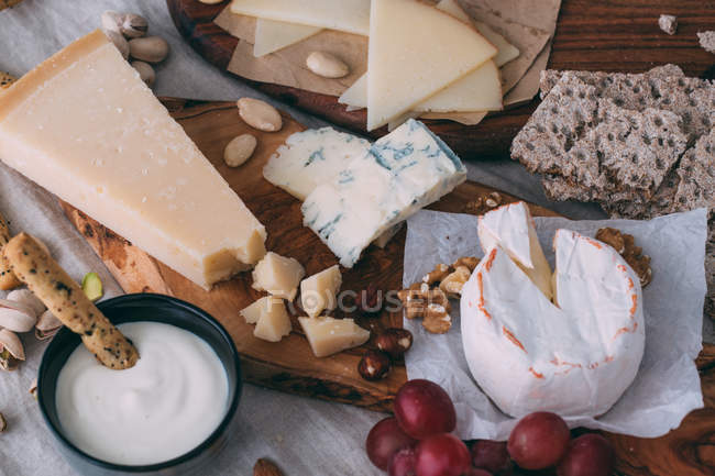 Cheese board with nuts and crostini — Stock Photo