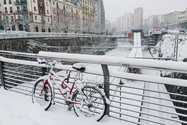 Red bicycle parked on bridge over railway in Bilbao, Spain. — Stock Photo