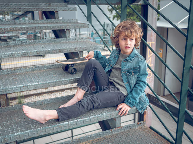 Descalço menino de pé na escada — Fotografia de Stock