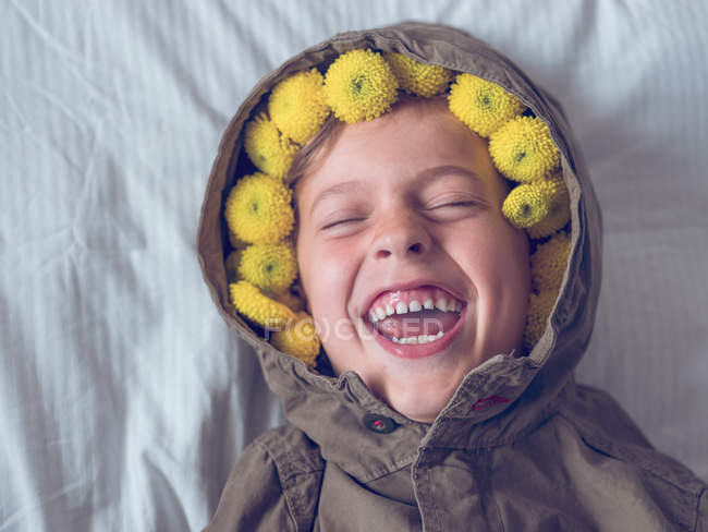 Niño en corona de flores amarillas - foto de stock